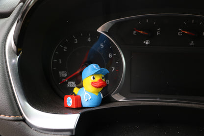 EMT Duck sitting near the instrument panel on a car's dashboard